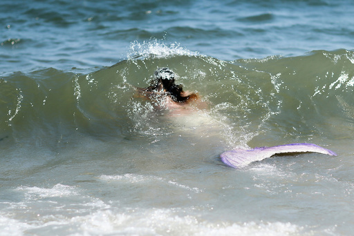 A participant dressed as a mermaid goes to swim after taking part in the Annual Mermaid Parade in Brooklyn