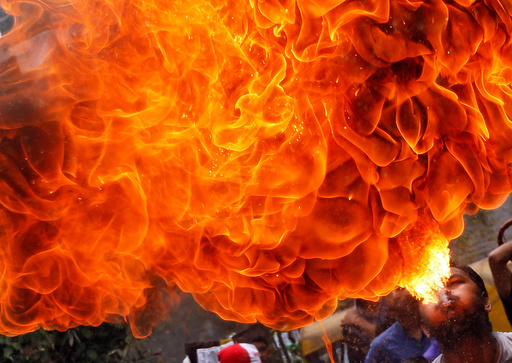 A Hindu devotee performs a stunt with fire during a rehearsal for the annual Rath Yatra in Ahmedabad