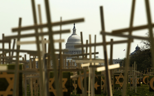 With the U.S. Capitol in the background, crosses symbolizing grave markers are placed upon the National Mall in Washington
