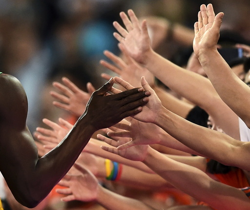 Usain Bolt of Jamaica shakes hands with fans after winning the men's 200 metres final during the 15th IAAF World Championships at the National Stadium in Beijing
