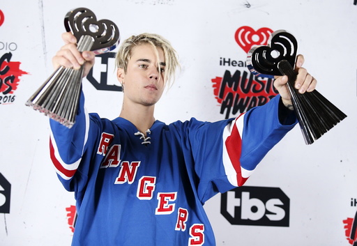 Recording artist Justin Bieber poses with his Dance Song of The Year Award for Where Are U Now and Male Artist of the Year Award backstage at the 2016 iHeartRadio Music Awards in Inglewood