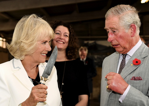 Britain's Prince Charles watches on as Camilla, Duchess of Cornwall holds a knife as they visit Seppeltsfield Winery in South Australia's Barossa Valley