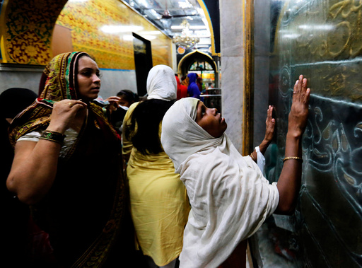 A woman prays at a shrine before breaking her fast during the holy month of Ramadan, in Mumbai