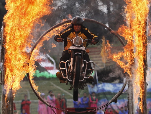 A Kashmiri policeman performs a stunt on a motorbike through a ring of fire during India's Independence Day celebrations in Srinagar