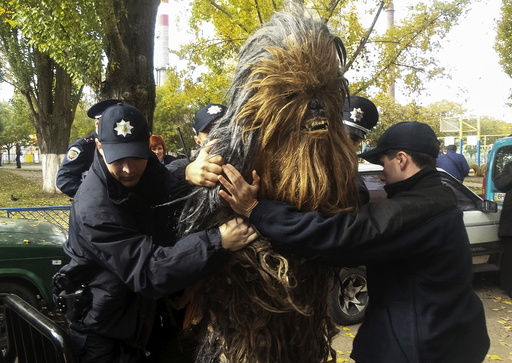 Policemen detain a person dressed as Star Wars character Chewbacca during a regional election near a polling station in Odessa