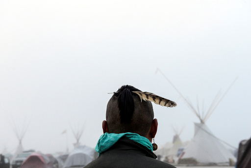 A man from the Muskogee tribe looks at the Oceti Sakowin shrouded in mist during a protest against the Dakota Access pipeline near the Standing Rock Indian Reservation near Cannon Ball, North Dakota