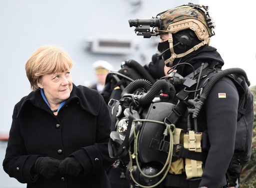German Chancellor Merkel looks at a combat diver during her visit to Naval Base Command in Kiel