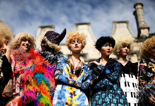 Models pose against the backdrop of an old sandstone chapel during a fashion show for the label Romance Was Born on the waterfront of Sydney Harbour during Australian Fashion Week, Sydney