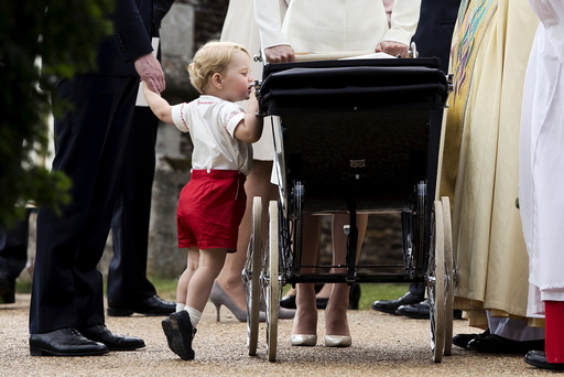 Britain's Prince George looks into the pram of his sister Princess Charlotte after her christening at the Church of St. Mary Magdalene in Sandringham