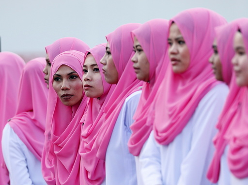 Women members of Malaysia's ruling United Malays National Organisation (UMNO) party wait for Prime Minister Najib Razak to arrive for the annual assembly at the Putra World Trade Centre in Kuala Lumpur
