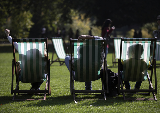 People are silhouetted against their deck chairs as they pose for a 