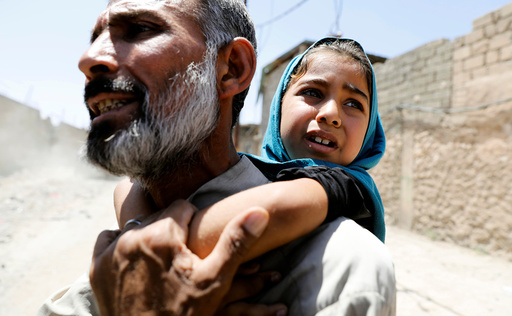 A man carries his daughter on his back after fleeing their home due to fighting between the Iraqi forces and Islamic State militants in Mosul's al-Zanjili's district in Iraq