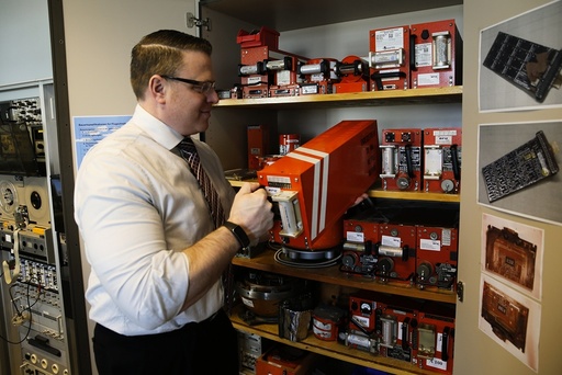 An employee of Germany's Bundesamt fuer Fluguntersuchung BFU removes a flight recorder from a cupboard at their headquarters in Braunschweig