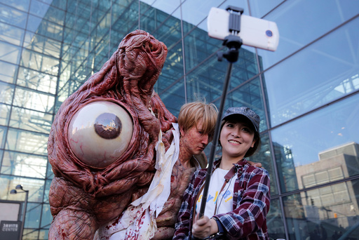 Chen Yifa from China poses for a selfie with a man dressed as William Birkin from Resident Evil at New York Comic Con in Manhattan