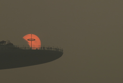 People watch the sun set from the observatory deck of the Marina Bay Sands hotel in Singapore