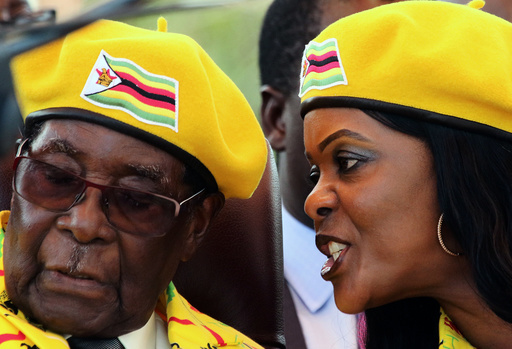 President Robert Mugabe listens to his wife Grace Mugabe at a rally of his ruling ZANU-PF party in Harare