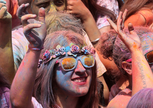 Woman coloured by powder dances during the Holi festival in Santa Coloma de Gramenet