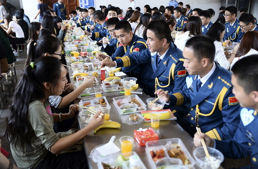 Soldiers of People's Liberation Army of China Air Force talk to women as they have lunch together during a match-making event for military personnel, at a military base in Wuhan