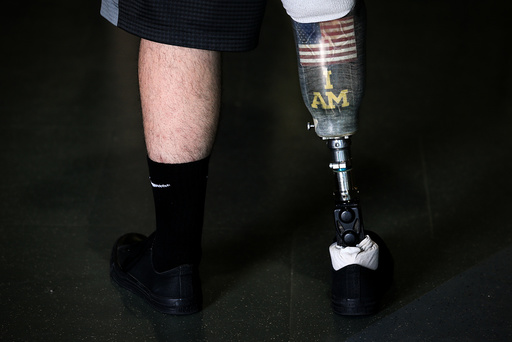 Wounded warrior Steven Davis poses for a photo with his prosthetic leg with a U.S. flag and Invictus Games I Am slogan on it at the Invictus Games in Orlando Florida