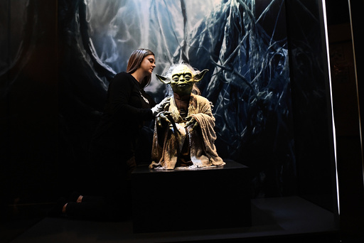 Kathy Smeaton, helps unpack the Yoda puppet used in the original movies, at the Star Wars Identities exhibition at the 02 in London