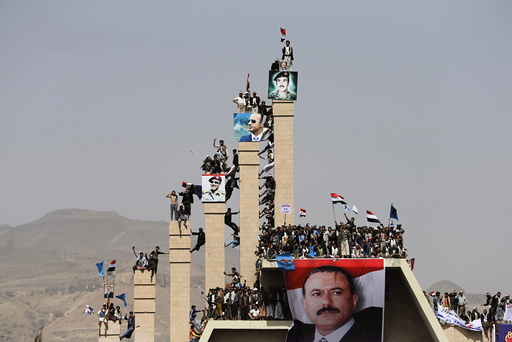 Supporters of Yemen's former President Ali Abdullah Saleh climb pillars of the Unknown Soldier Monument during a rally marking one year of Saudi-led air strikes in Yemen's capital Sanaa
