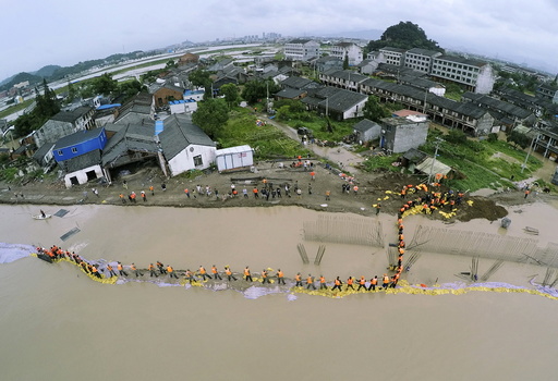 An aerial view shows PLA soldiers and local residents placing sand bags to block the flood water after a dam breached under the influence of Typhoon Soudelor, in Pingyang county