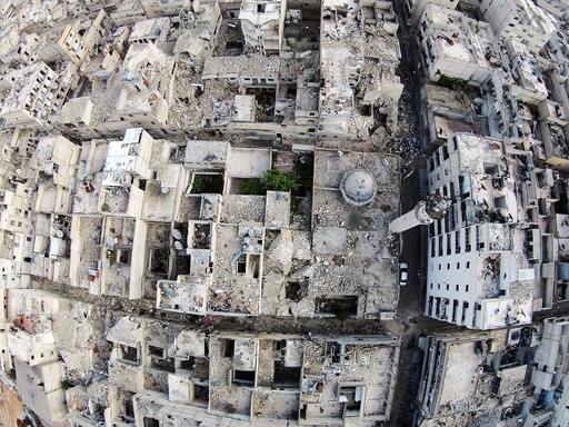 A aerial view shows a damaged mosque and surrounding buildings in the Al-Maysar neighbourhood of Aleppo