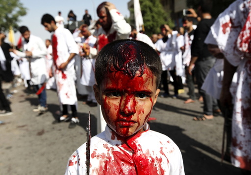 An Iraqi Shi'ite boy poses for a photograph as Iraq Shi'ite Muslims commemorate Ashura in Baghdad