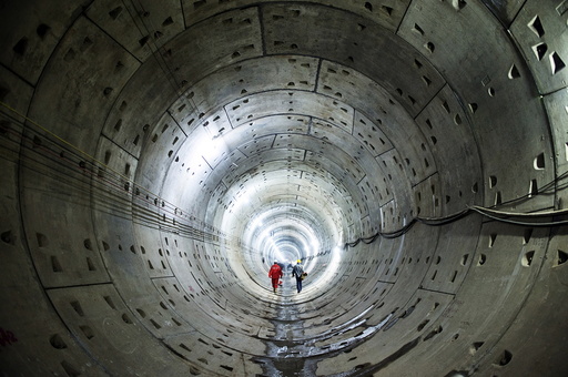 Workers walk along a tunnel of a subway construction site in Changsha, Hunan province