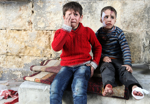 Injured boys react at a field hospital after airstrikes on the rebel held areas of Aleppo