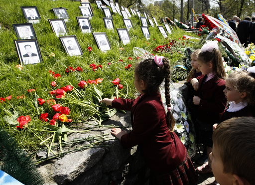 Children lay flowers at a monument to victims of the Chernobyl nuclear disaster in Kiev