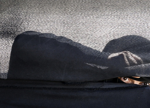 Woman looks through a tent during a gathering by Houthi loyalists against Saudi-led air strikes in Yemen's capital Sanaa