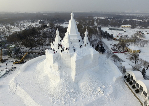 Workers polish a snow sculpture ahead of the annual Harbin International Ice and Snow Festival, in Harbin