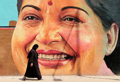 A woman walks past a portrait of J. Jayalalithaa, Chief Minister of the southern state of Tamil Nadu, in Chennai