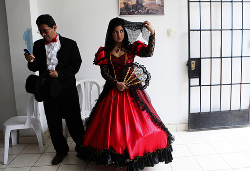 A couple wearing traditional clothes wait for the start of a mass wedding ceremony, in the district of Comas in Lima