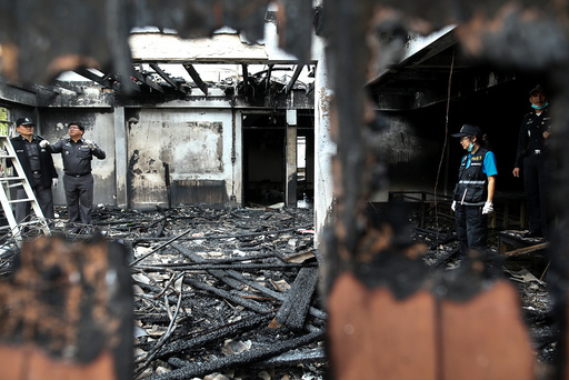 Forensic experts inspect a burnt building at the Pitakkiat Wittaya School in the northern province of Chiang Rai