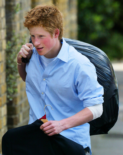 BRITAIN'S PRINCE HARRY CARRIES OUT HIS BELONGINGS AS HE LEAVES ETON COLLEGE.