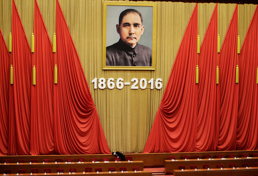 An attendant checks seats after a conference commemorating the 150th birth anniversary of Sun Yat-Sen in Beijing