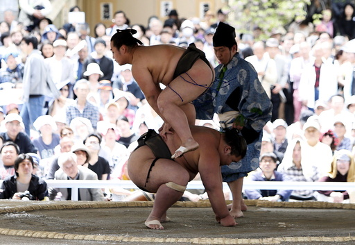 Sumo wrestlers perform a show fight during the annual 'Honozumo' ceremonial sumo tournament dedicated to the Yasukuni Shrine in Tokyo, Japan