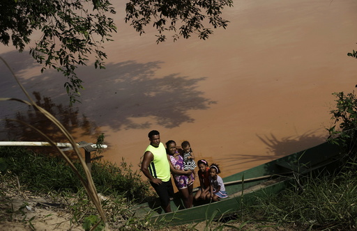 Gilmar, who lives at a farm on the banks of of Rio Doce, which was flooded with mud after a dam, owned by Vale SA and BHP Billiton Ltd burst, poses with his family in Linhares