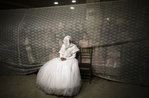 Ultra-orthodox Jewish bride watches her groom dance during their wedding ceremony in Jerusalem