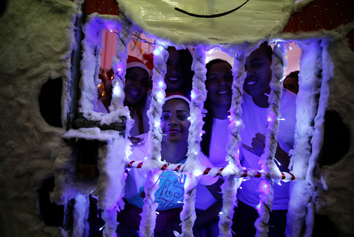 Prisoners look through the bars of their prison cell during a Christmas decorating event 