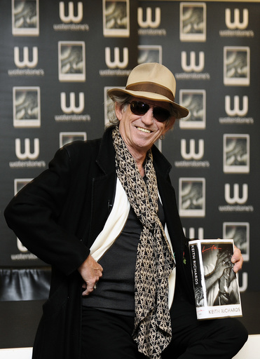British musician Keith Richards poses for photographers with a copy of his autobiography 