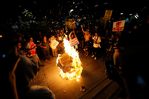 A Donald Trump pinata is burned by people protesting the election of Republican Donald Trump as the president of the United States in downtown Los Angeles