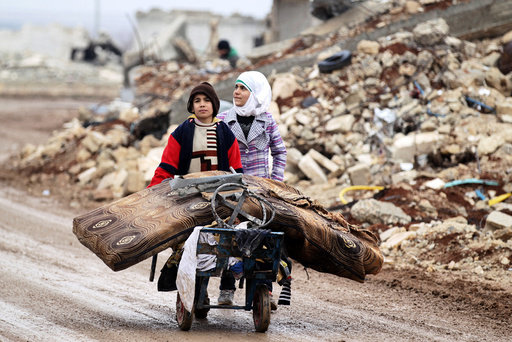 Samah, 11, and her brother, Ibrahim, transport their salvaged belongings from their damaged house in Doudyan village in northern Aleppo Governorate