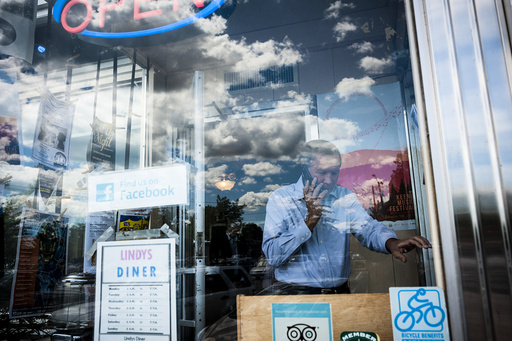 Ohio Gov. John Kasich, a Republican presidential hopeful, takes a call ahead of a walking tour of Main Street during a campaign stop in Keene, N.H.