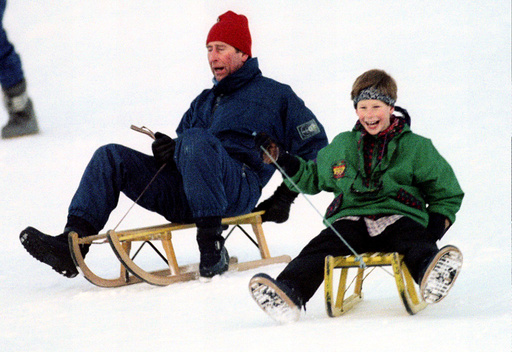 The Prince of Wales (L) and his son Prince Harry share a laugh as they toboggan in Klosters on Janua..