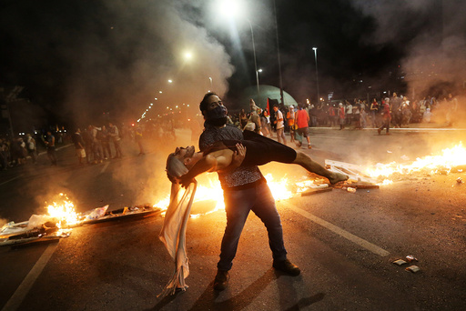 Anti-government demonstrators perform in front of burning barricades as they attend a protest against a constitutional amendment, known as PEC 55, that limit public spending, in front of Brazil's National Congress in Brasilia