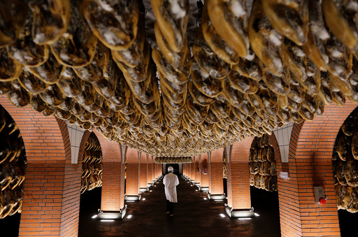 A worker walks in a cellar of cured high-quality Iberian ham legs in Jabugo, southern Spain