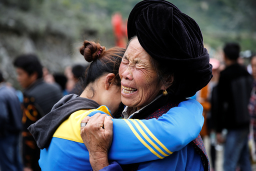 Relatives of victims react at the site of a landslide in the village of Xinmo, Mao County